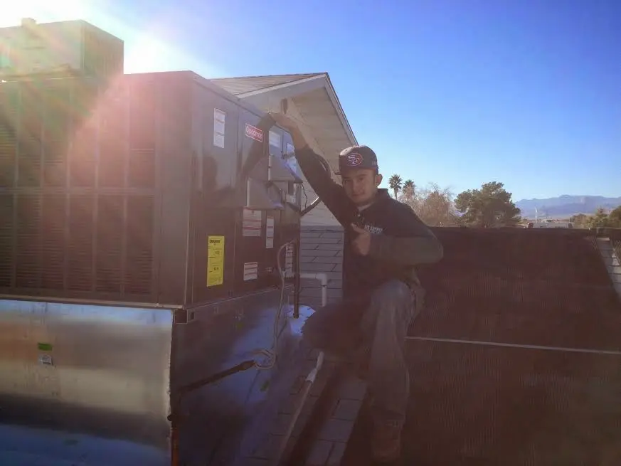 HVAC technician performing AC Tune-Up on a rooftop unit in Marathon